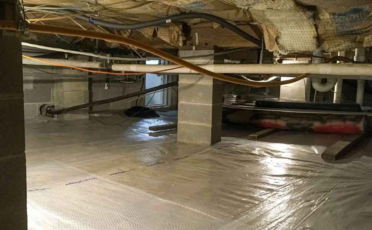 crawl-space-vapor-barrier Crawl space lined with white vapor barrier for moisture control in Pensacola, FL<br />