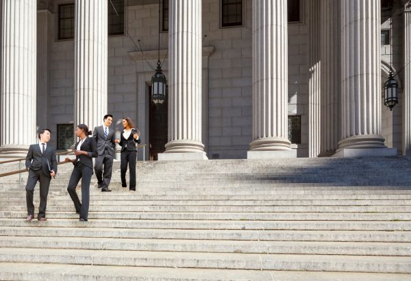 people walking down steps of a municipal building